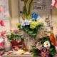 Farbenfroher Arbeitsplatz übersät mit Blumensträußen, Geschenken und Dekorationen