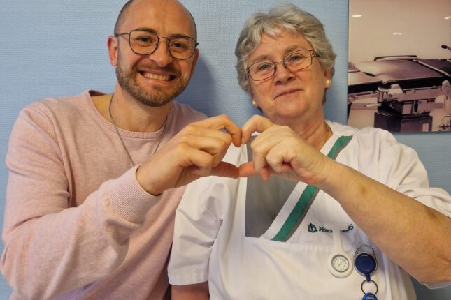 "Pflegekraft Wjatscheslaw Schaefer von Asklepios und eine erfahrene Kollegin in Rente formen ein Herz mit ihren Händen."