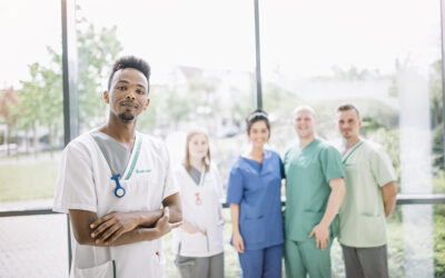 flegeauszubildende der Asklepios Kliniken am BZG Nordhessen in Berufsbekleidung vor Glasfassade