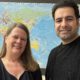 Stefanie Ludwig und Ebrahim vor einer Weltkarte im Asklepios Willkommenszentrum Hamburg