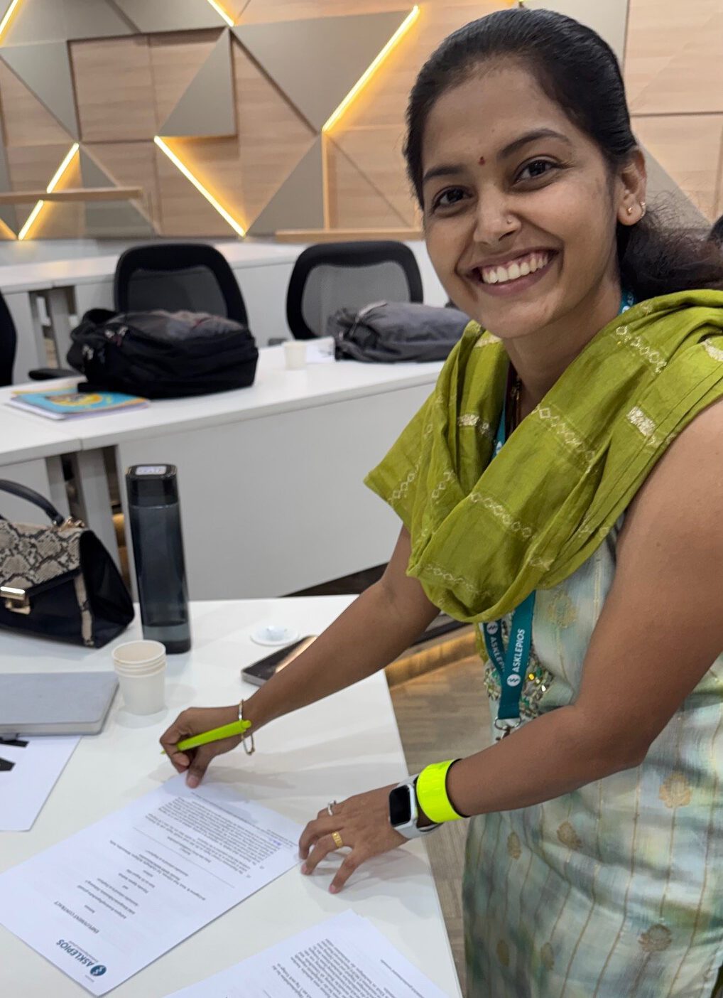 Indische Pflegekraft lächelt beim Unterzeichnen ihres Arbeitsvertrags mit Asklepios im Rahmen des internationalen Rekrutierungsprogramms.